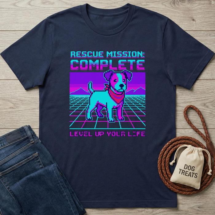 Navy blue t-shirt with a dog graphic and text on a wooden surface with jeans and a drawstring bag.