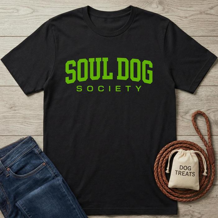 Black cotton Soul Dog Society t-shirt with bright green text, next to jeans and dog treats.