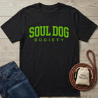 Black cotton Soul Dog Society t-shirt with bright green text, next to jeans and dog treats.