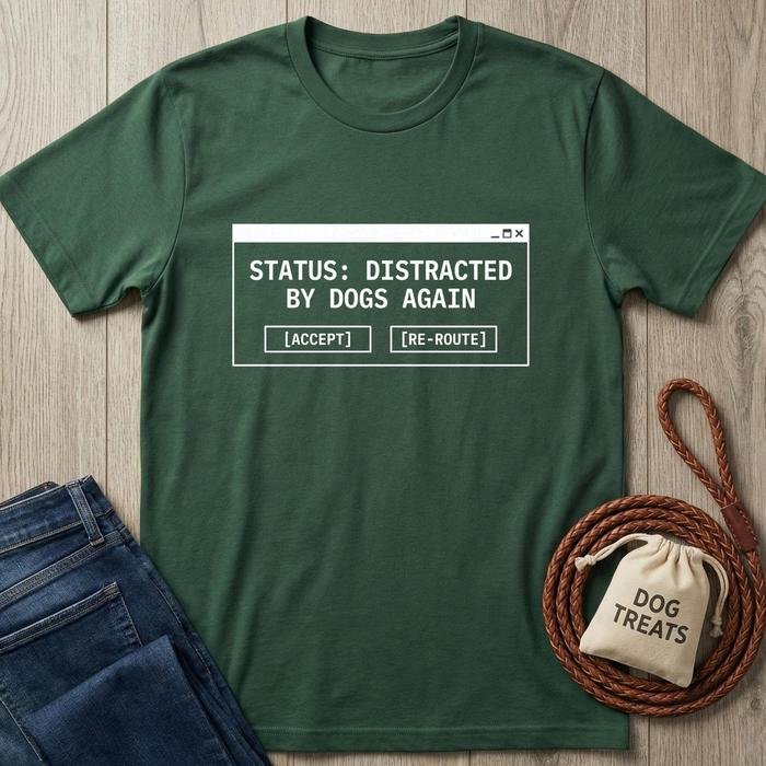 Green t-shirt with text 'Status: Distracted by Dogs Again' on a wooden surface with jeans and a dog treat bag.