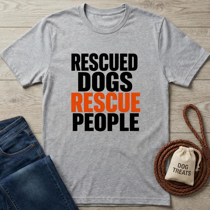Gray t-shirt with 'Rescued Dogs Rescue People' text on a wooden surface with jeans and dog treats.