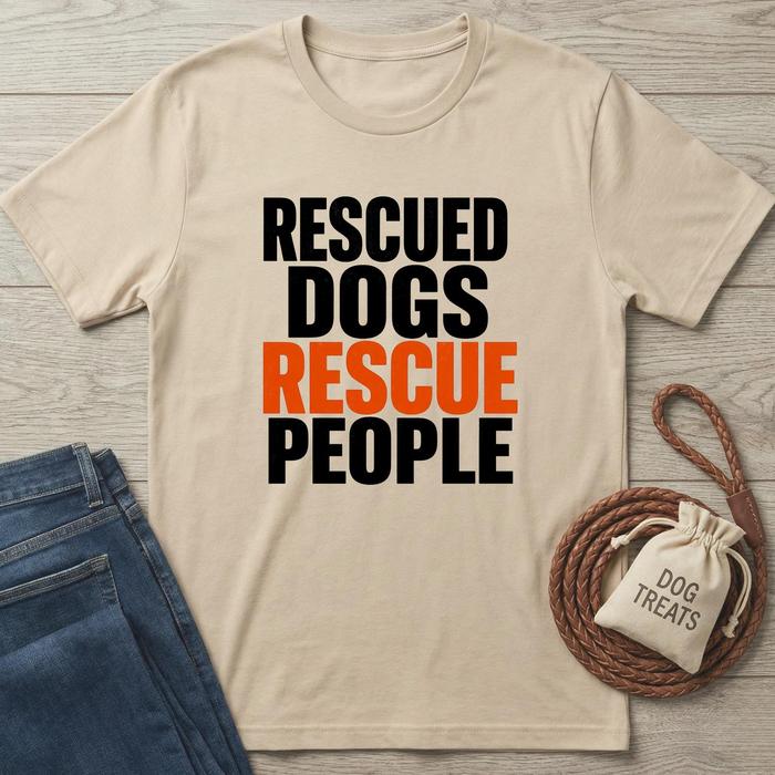 Beige t-shirt with 'Rescued Dogs Rescue People' text, paired with jeans and a dog treat bag on a wooden surface.
