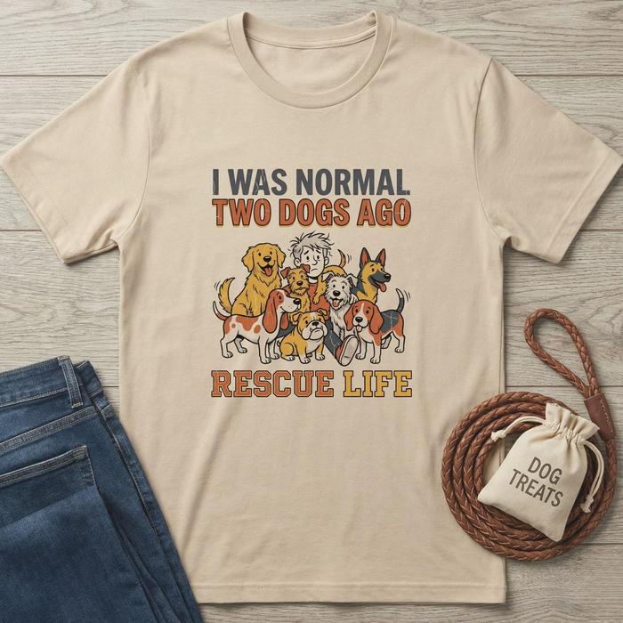Beige cotton t-shirt with "I WAS NORMAL TWO DOGS AGO RESCUE LIFE" text and cartoon dogs.