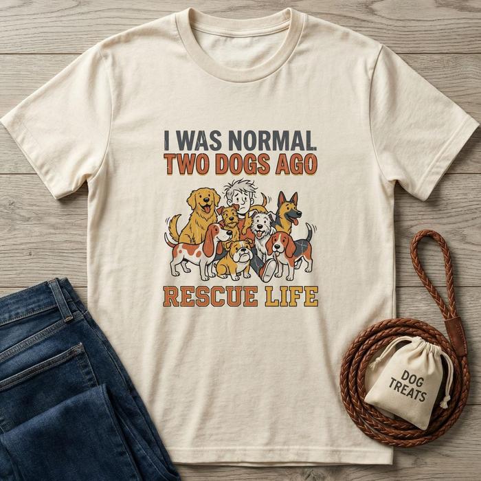Cream t-shirt with "I Was Normal Two Dogs Ago Rescue Life" text and cartoon dogs.