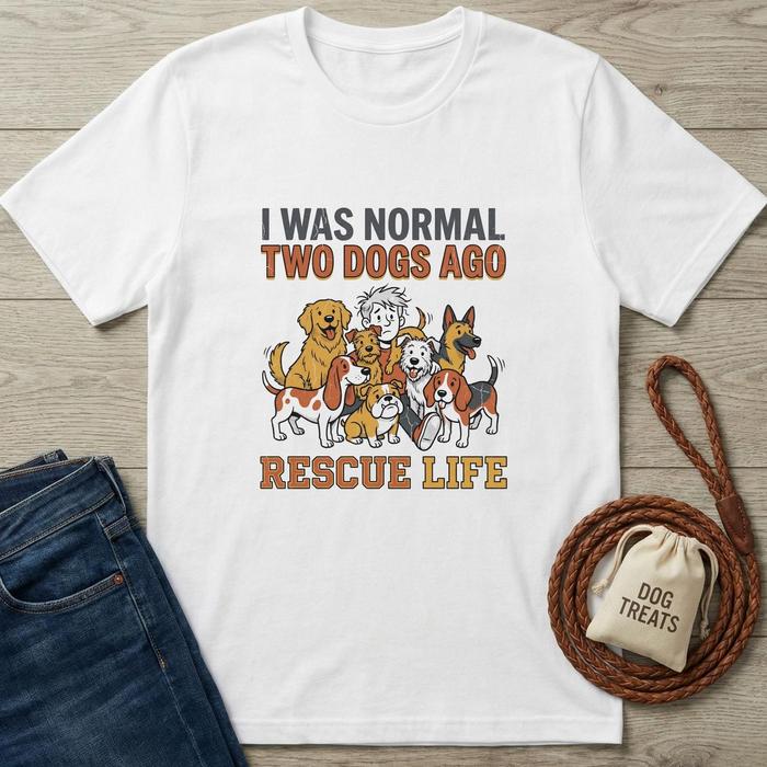 White cotton t-shirt with "I Was Normal Two Dogs Ago Rescue Life" text and cartoon dogs.