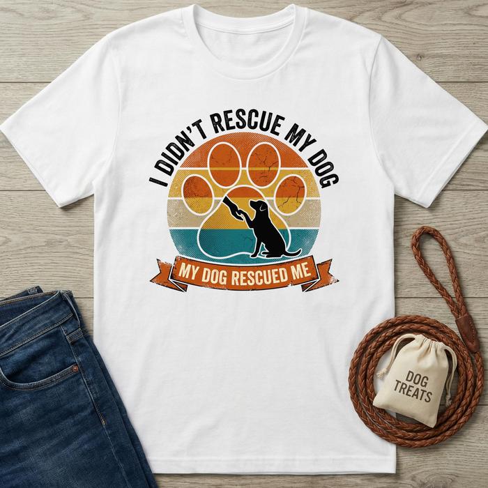 White cotton t-shirt with a vintage sunset paw print design and "My Dog Rescued Me" text.