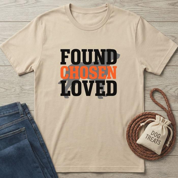 Beige cotton t-shirt with "FOUND CHOSEN LOVED" text, a dog silhouette, jeans, and dog treats.