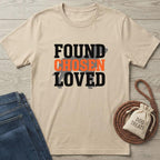 Beige cotton t-shirt with "FOUND CHOSEN LOVED" text, a dog silhouette, jeans, and dog treats.