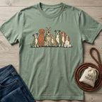 Sage green cotton t-shirt with a graphic of eight diverse dog breeds in a line.