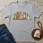 Gray cotton t-shirt with a colorful illustration of seven diverse dog breeds, next to blue jeans and dog treats.