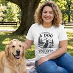 Woman in a white "Sometimes a Dog Is All You Need" graphic tee petting a golden retriever in a park.