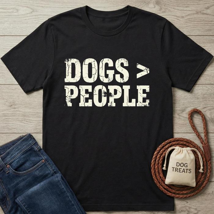 Black cotton t-shirt with distressed "DOGS > PEOPLE" text, next to blue jeans and dog treats.