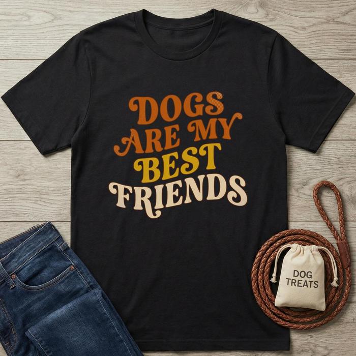 Black cotton t-shirt with "Dogs Are My Best Friends" in orange and yellow retro font, next to jeans and dog treats.