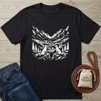 Black Gildan Softstyle® 64000 t-shirt with white mountain, forest, and two dog design; next to jeans and dog treats.