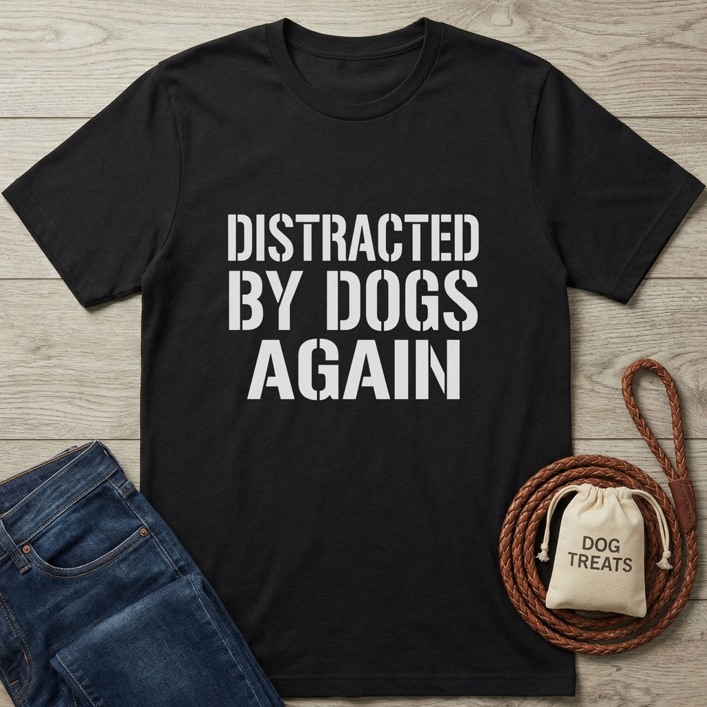 Black Gildan Softstyle® 64000 t-shirt with "DISTRACTED BY DOGS AGAIN" in white text, next to jeans and dog treats.