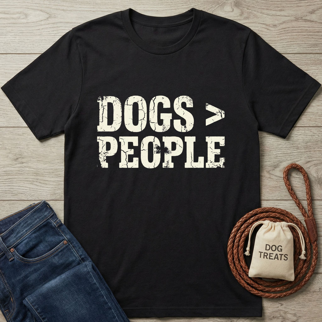 Black Gildan Softstyle 64000 tee with "DOGS > PEOPLE" distressed text, next to jeans and dog treats.