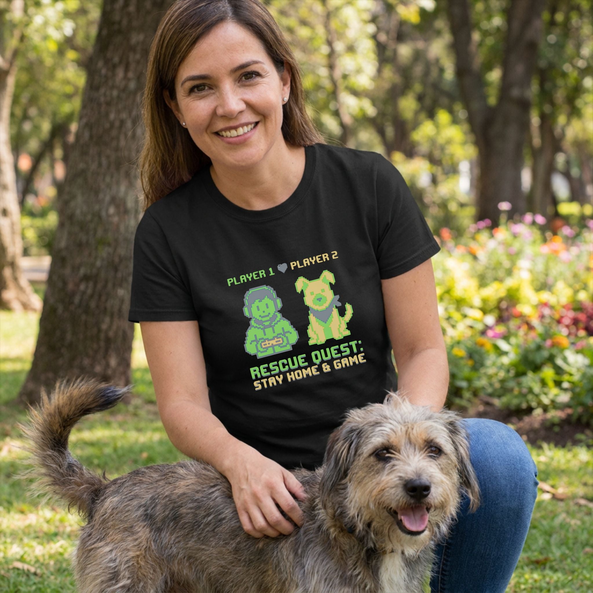 Woman in a black "Rescue Quest" t-shirt with pixel art petting a scruffy dog outdoors.