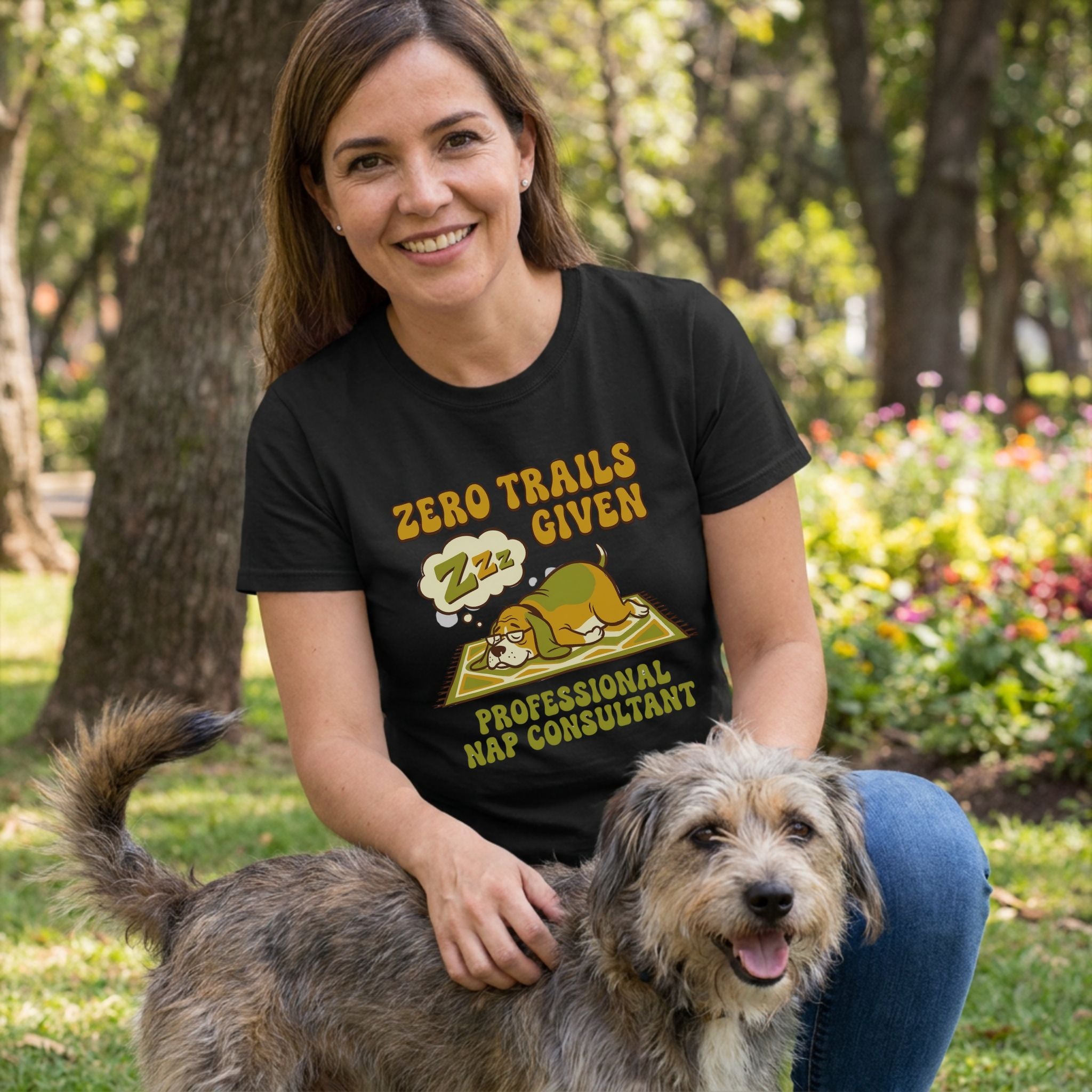 Woman in black "Zero Trails Given" t-shirt with sleeping dog graphic, petting a scruffy dog outdoors.