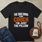 Black Gildan Softstyle® t-shirt with "The Dog Owns The Couch I'm Just The Pillow" text in white and orange.
