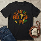 Black cotton t-shirt with "My Dog Has Good Taste In Humans" in colorful, circular text.