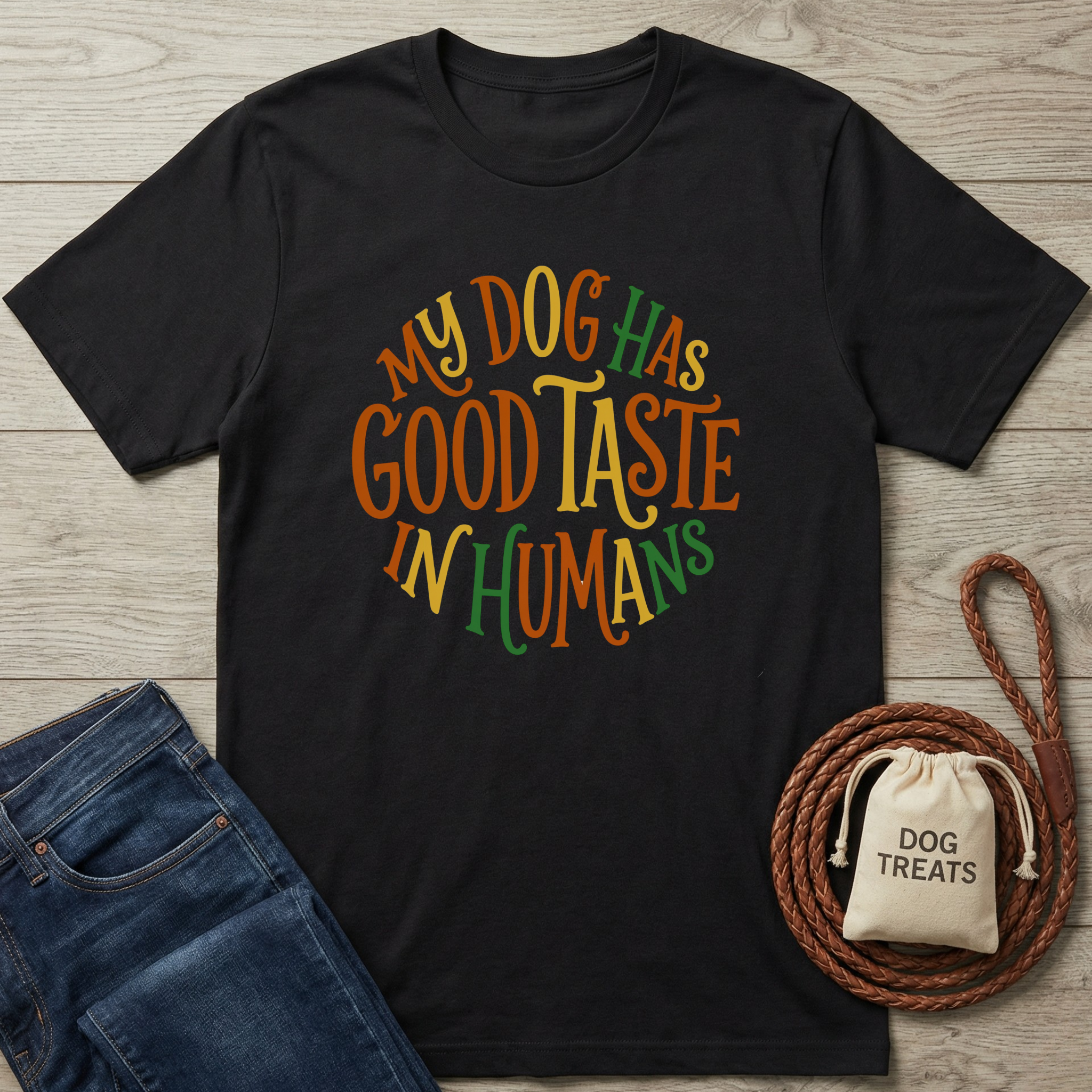 Black cotton t-shirt with "My Dog Has Good Taste In Humans" in colorful, circular text.