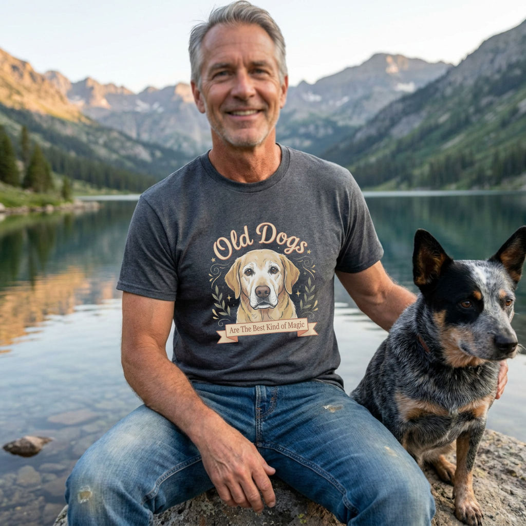 Man in a charcoal grey "Old Dogs Are The Best Kind of Magic" t-shirt with a yellow lab graphic, next to a dog.