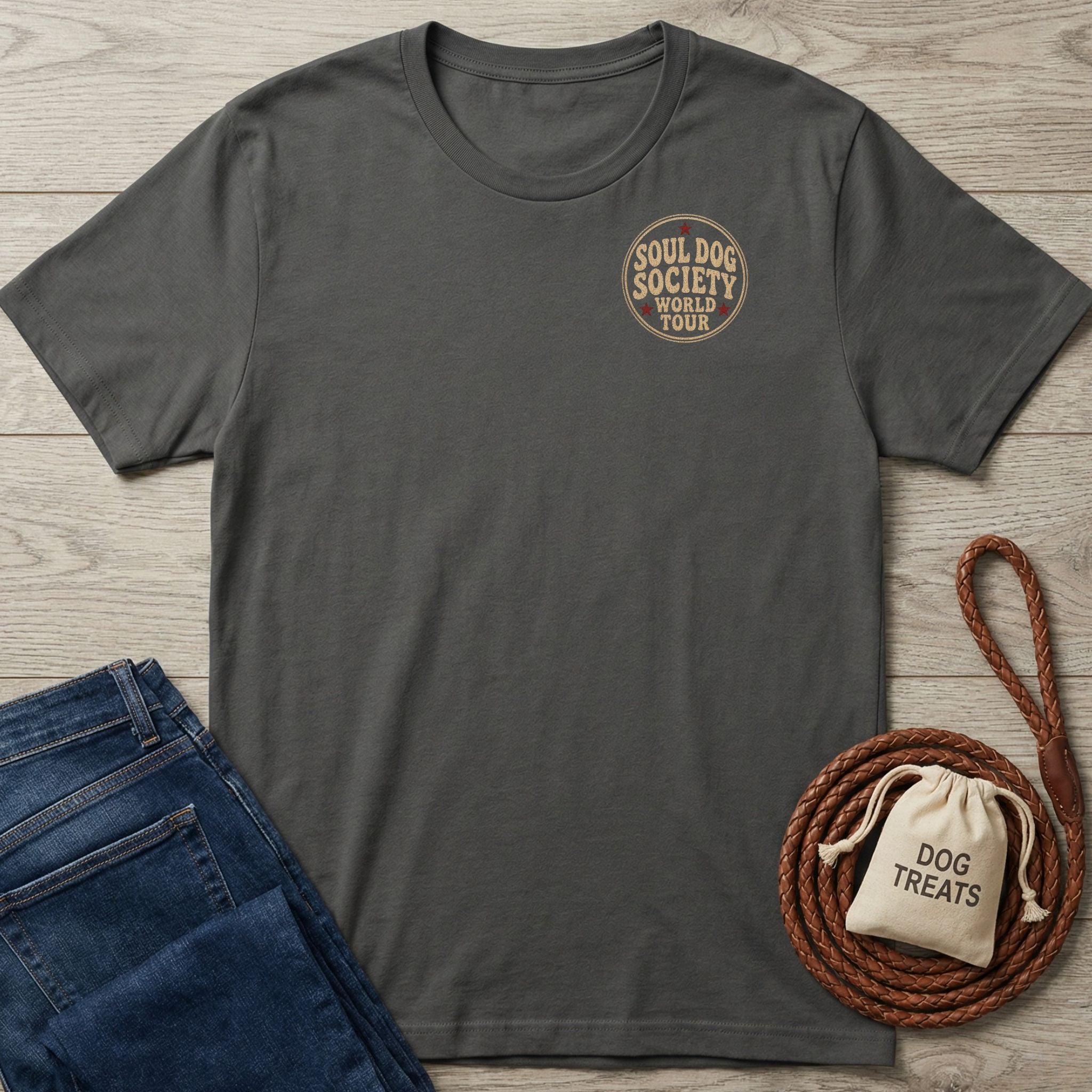 Charcoal grey Soul Dog World Tour T-shirt with a small circular logo, next to blue jeans and a dog leash.