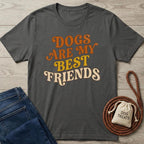 Dark gray cotton t-shirt with "Dogs Are My Best Friends" in retro orange and yellow text, next to jeans and dog treats.