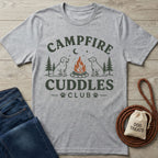 Grey crewneck t-shirt featuring a campfire, pine trees, and two dogs with the text Campfire Cuddles Club printed on front.