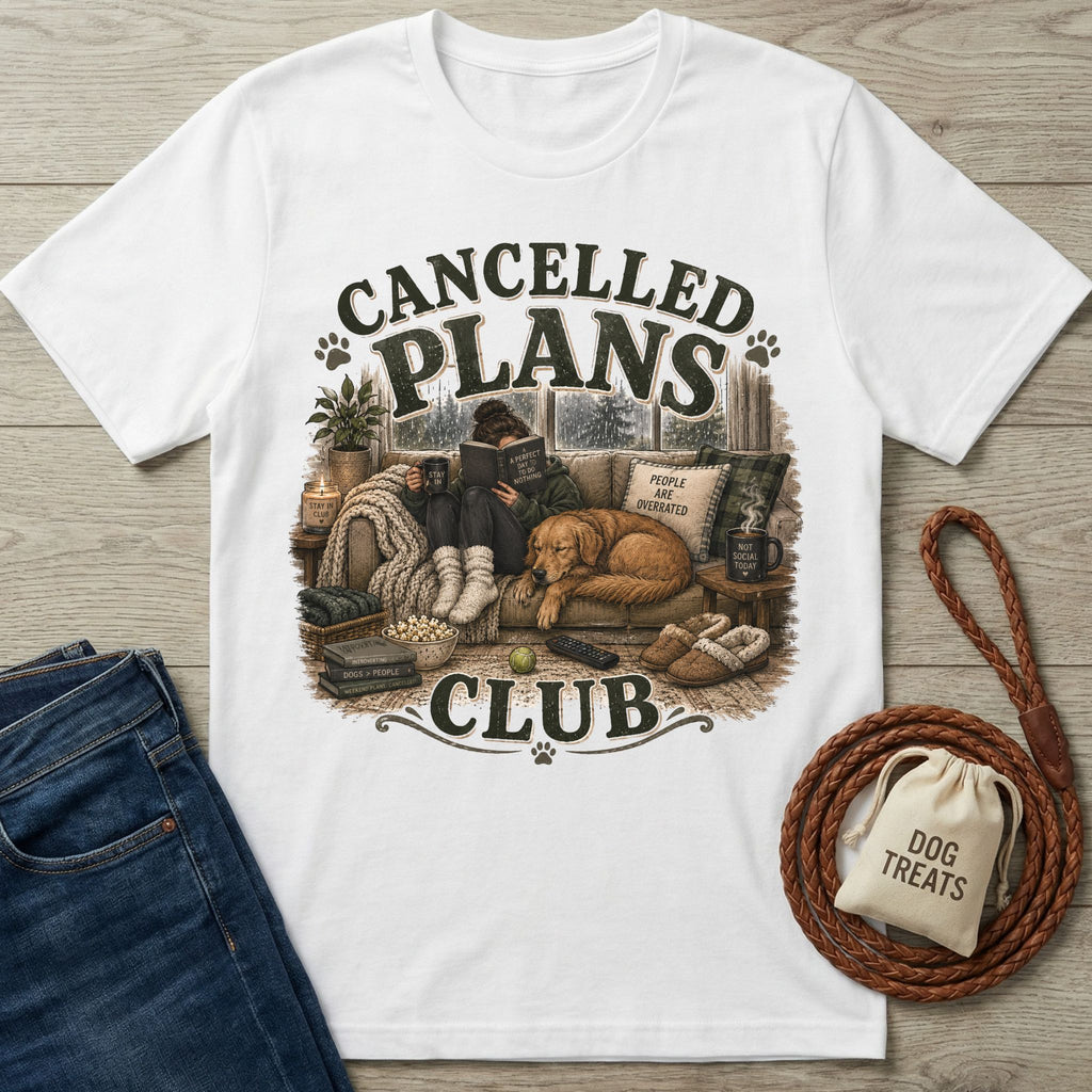 White cotton t-shirt featuring a cozy illustration of a person reading with a dog on a couch, labeled Cancelled Plans Club.