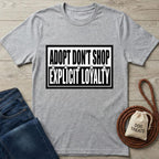 Gray cotton t-shirt with "ADOPT DON'T SHOP EXPLICIT LOYALTY" text, paw prints, jeans, and dog treats.