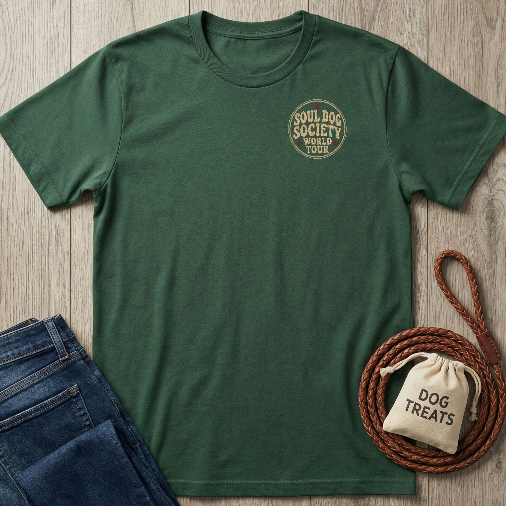 Forest green Soul Dog World Tour t-shirt with a small chest graphic, folded jeans, and dog treats.