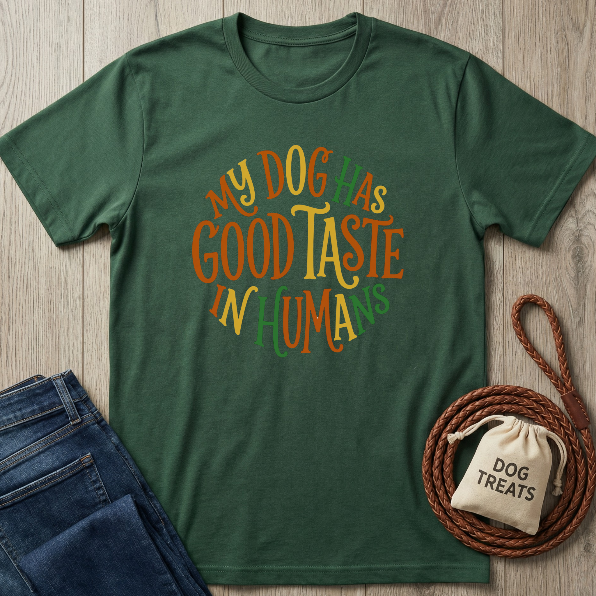 Dark green cotton t-shirt with "My Dog Has Good Taste In Humans" in orange, yellow, and green text.