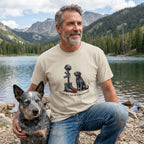 Man in a beige "Gone But Never Forgotten" t-shirt with a soldier's cross and black dog, next to a blue heeler.