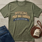 Olive green "Official Poop Bag Carrier" t-shirt with jeans, a leather leash, and a dog treat bag.