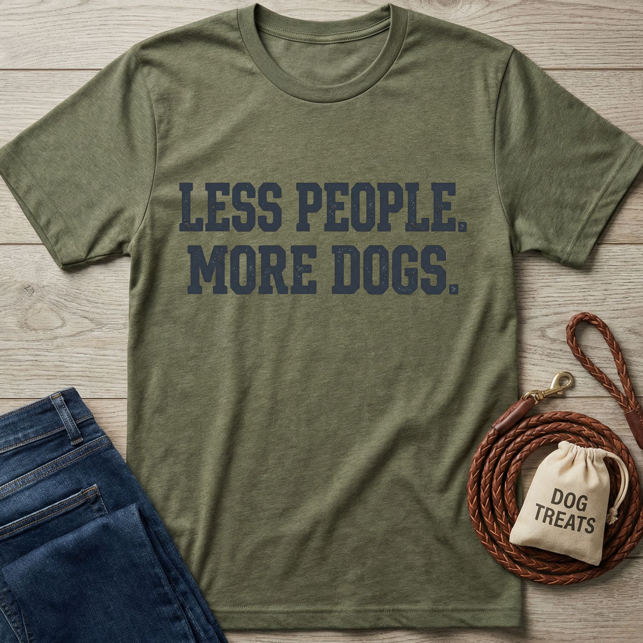 Olive green "Less People. More Dogs." t-shirt, blue jeans, coiled leather leash, and dog treats bag.