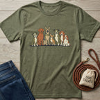 Olive green "The Pack" t-shirt with a graphic of seven diverse dogs, next to jeans and a dog leash.