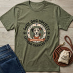 Olive green "Second Chance Club" t-shirt with a dog graphic, next to jeans, a leash, and dog treats.