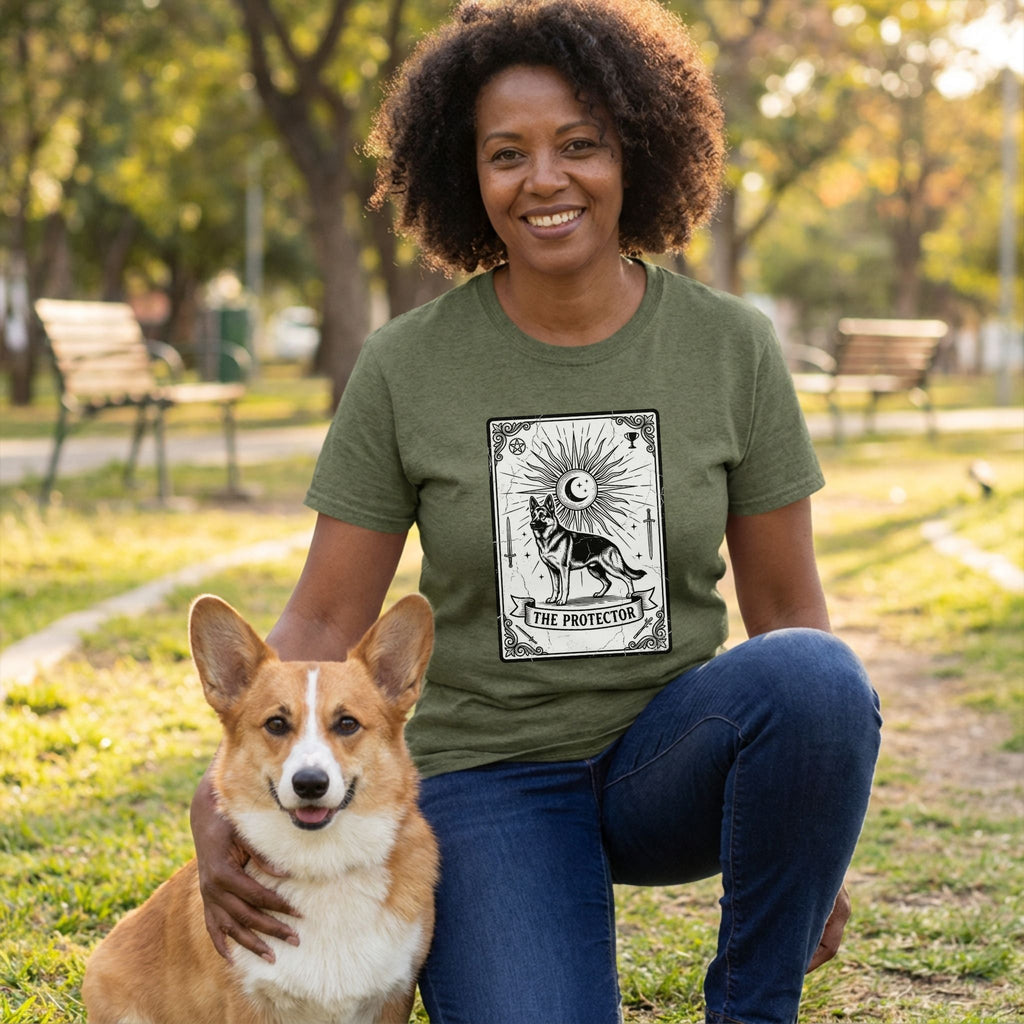 Woman in olive green "The Protector" Tarot card t-shirt with a German Shepherd design, kneeling with a Corgi.