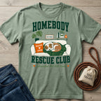 Sage green crewneck t-shirt featuring a graphic of a sleeping rescue dog on a couch with Homebody Rescue Club text.
