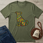 Olive green "Love In Color" t-shirt with a vibrant, colorful, patterned dog design, next to jeans and dog treats.