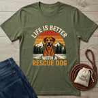 Olive green Gildan Softstyle® t-shirt with "Life Is Better With A Rescue Dog" graphic, featuring a dog, mountains, and sunset.