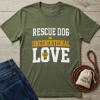 Olive green "Rescue Dog = Unconditional Love" t-shirt with a paw print heart, next to jeans and dog treats.