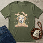 Olive green "Old Dogs Are The Best Kind of Magic" t-shirt with a yellow lab illustration, jeans, and dog treats.