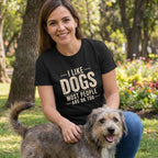 Woman in black "I Like Dogs Most People Are OK Too" tee petting a rescue dog outdoors.
