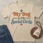 Beige crewneck t-shirt with vintage-style My Dog Is My Social Circle text, paw print, and heart graphic.