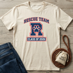 Cream "Rescue Team R Class of 2026" t-shirt with a paw print, next to jeans and dog treats.