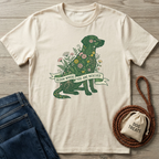 Cream cotton t-shirt with a green floral dog design and "Bloom Where You Are Rescued" banner.