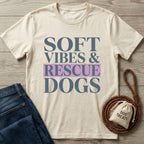 Cream Gildan Softstyle t-shirt with "SOFT VIBES & RESCUE DOGS" graphic, paired with jeans and dog accessories.
