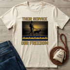 Cream Gildan Softstyle t-shirt with "Their Service Our Freedom" graphic featuring a soldier and dog.